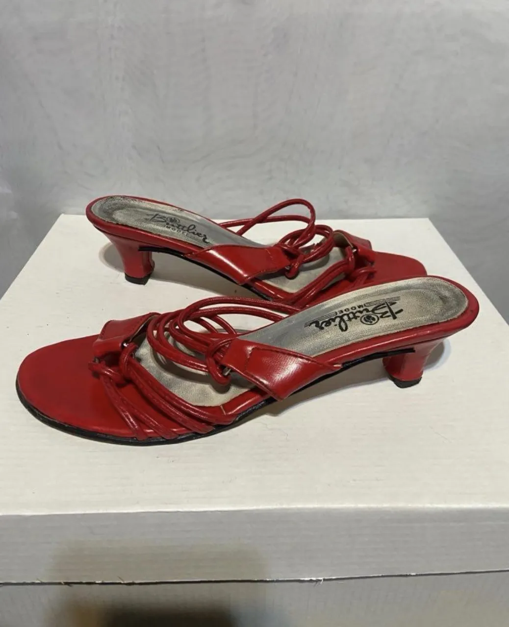 Sandalias rojas con tiras finas y taco bajo.