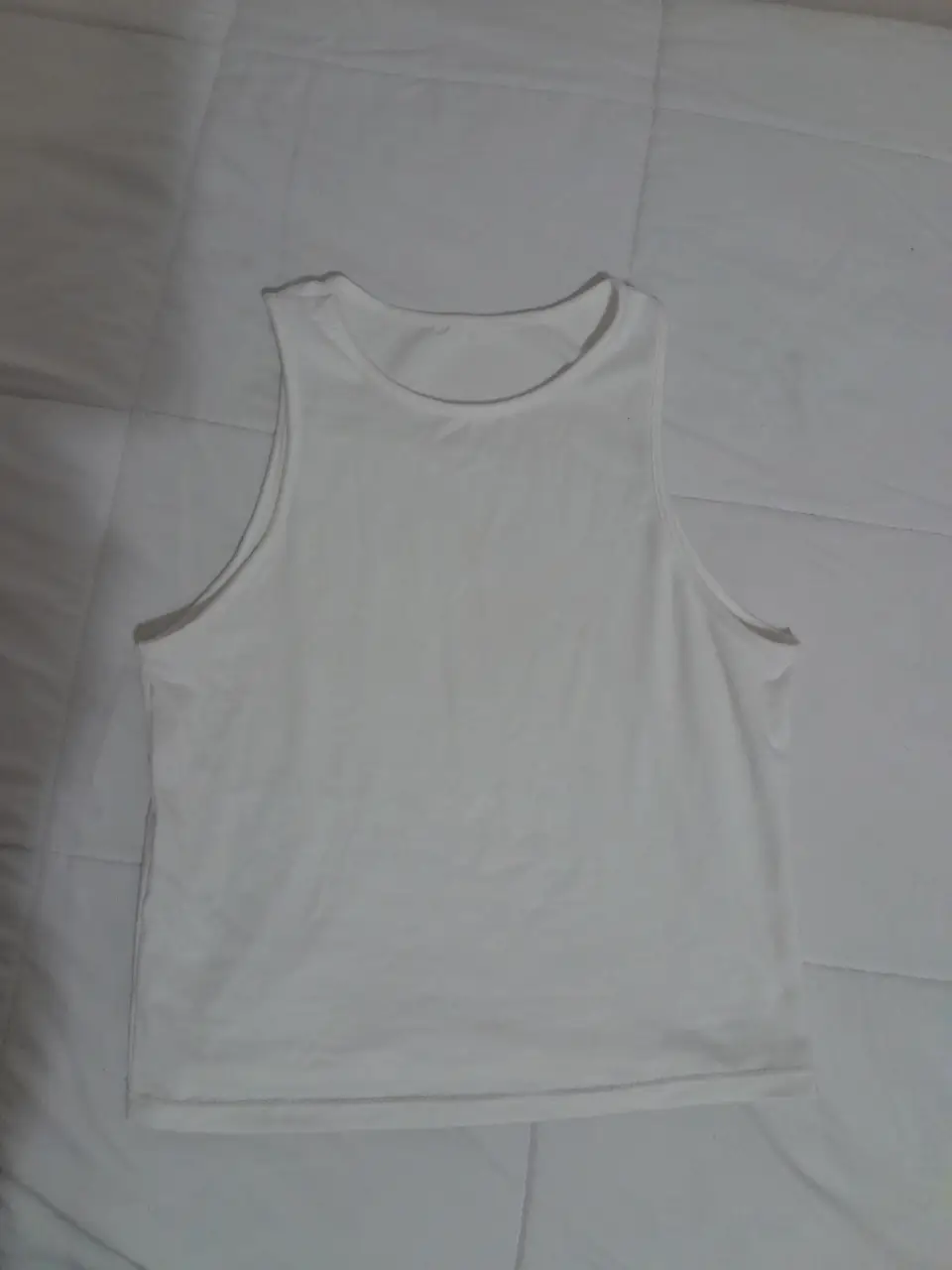 Top blanco de corte clásico, ideal para combinar con cualquier outfit. Perfecta para el día a día o para actividades deportivas. 