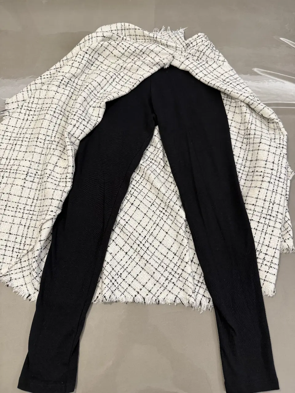 Pantalon y sobre falda a cuadros blanco y negro. Ideal para un look moderno y versátil.