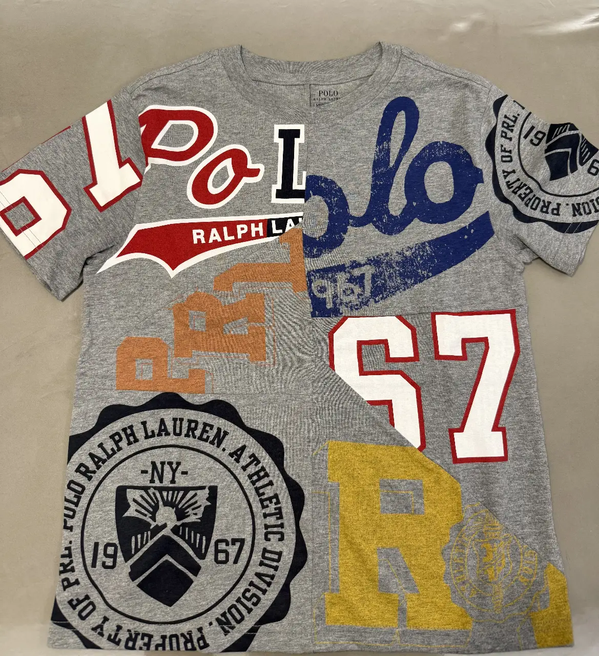 Remera de hombre Polo Ralph Lauren con estampado de logos y números en varios colores. Ideal para un look casual y urbano.