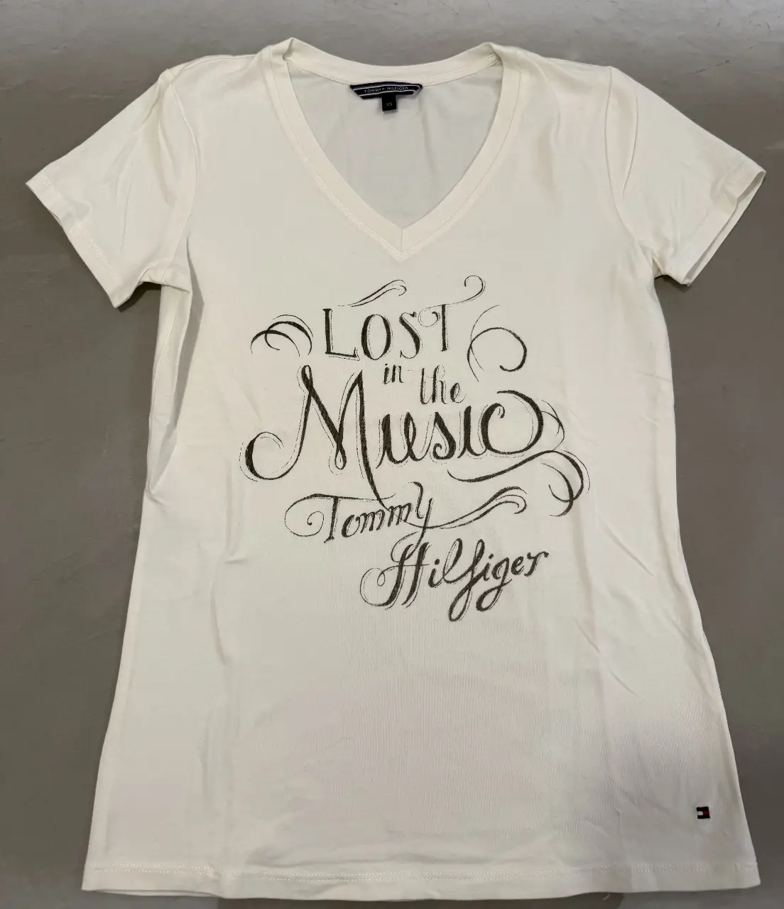 Remera de mujer con cuello en V y estampado "Lost in the Music" de Tommy Hilfiger. Talle XS.