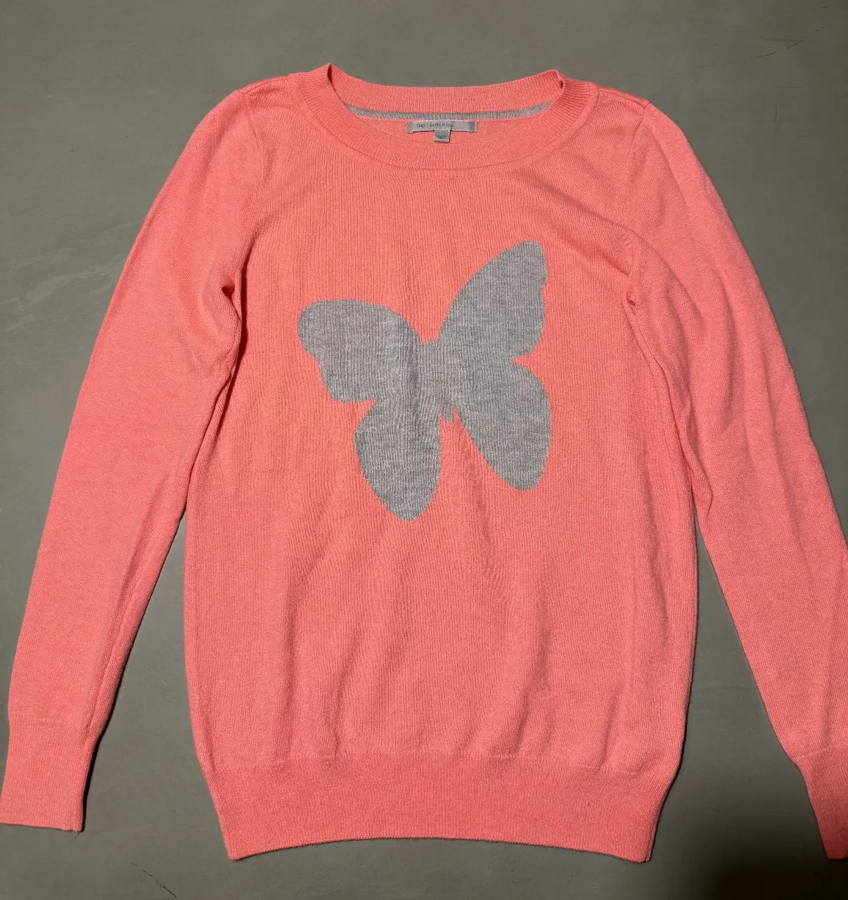 Sweater rosa de mujer con diseño de mariposa gris. Talle extra small. Ideal para un look casual y cómodo.