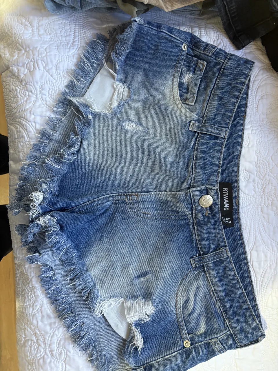Shorts de jean con roturas y flecos en los bordes.