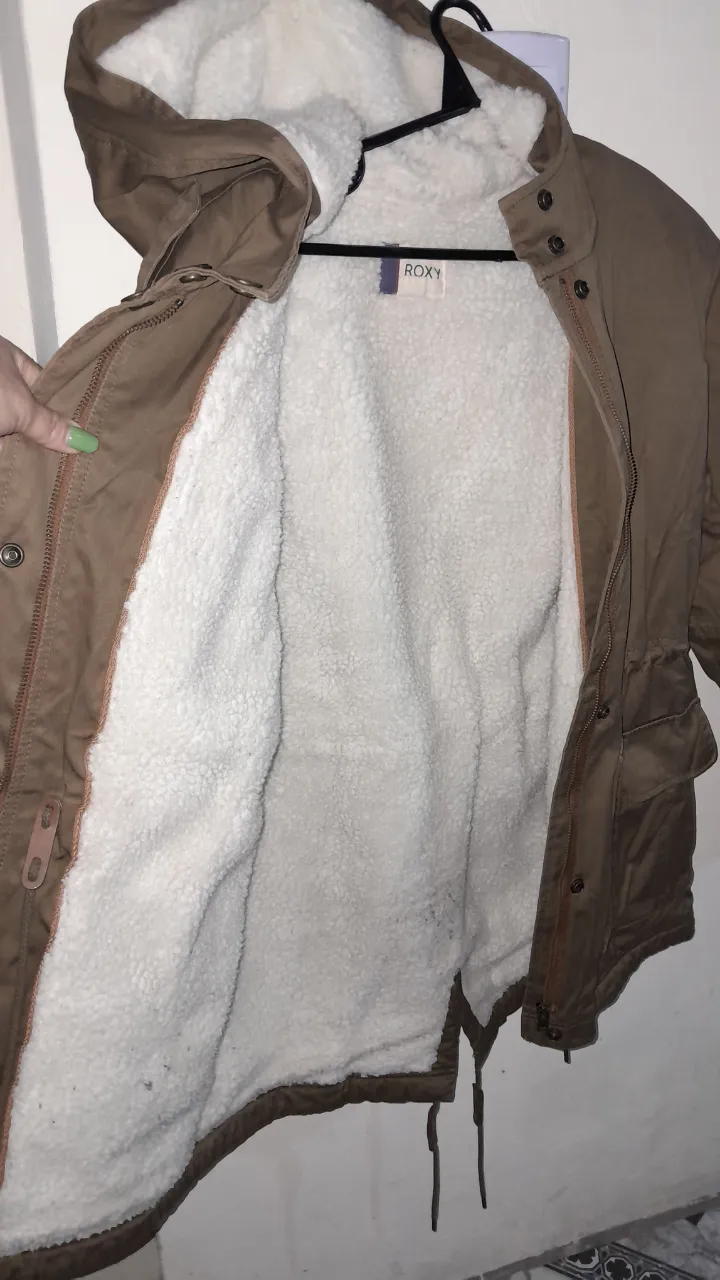 Campera de abrigo tipo parka, con capucha y forro de piel sintética. Ideal para el invierno. Posee bolsillos y ajuste en la cintura.
