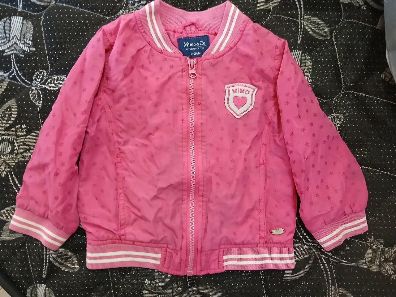 ¡Chaqueta bomber rosa súper linda para niñas! Con un estampado de estrellas y corazones, es perfecta para darle un toque divertido a cualquier look. Ideal para entretiempo.