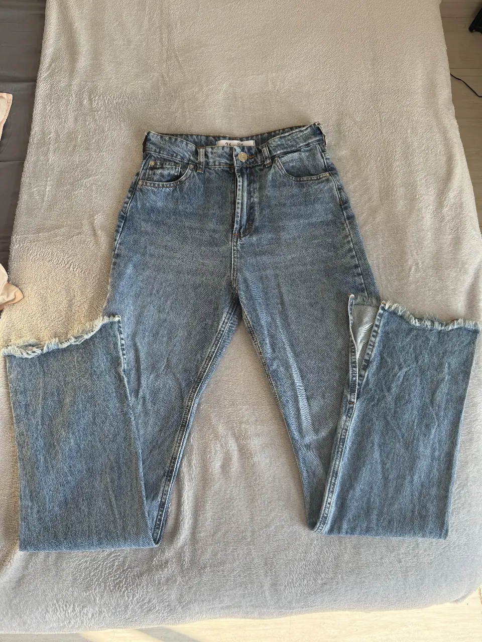 Jeans de mujer, tiro alto, con corte recto y detalles de roturas en el bajo. Talle 26. Complot