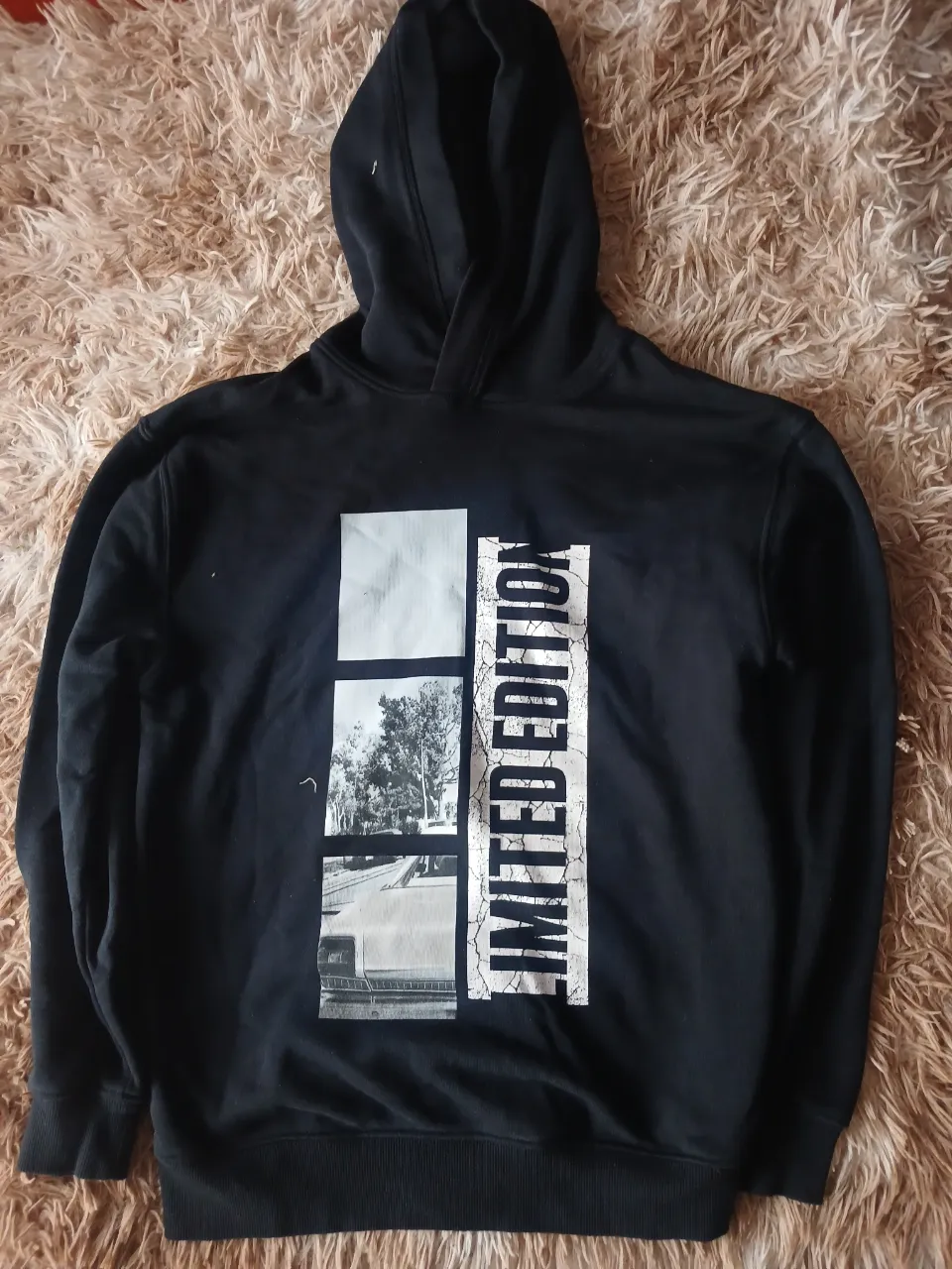 Buzo negro con capucha, con estampado Zara, en blanco y una imagen en blanco y negro. Ideal para un look casual y urbano.