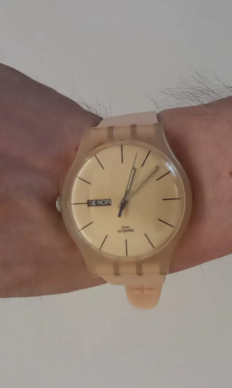 Reloj Swatch vintage de plástico rosa, con dial amarillo y calendario. Un clásico de los 90s, ideal para un look retro y casual.