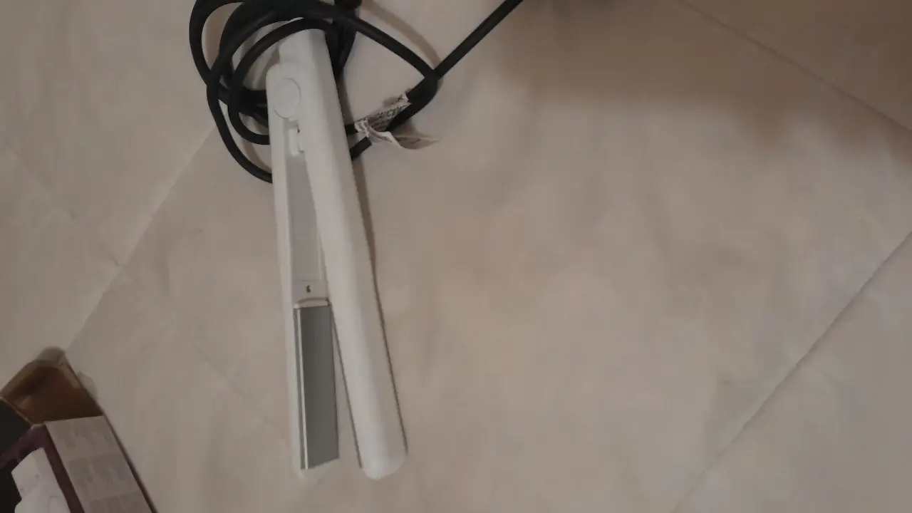 Plancha de pelo blanca, ideal para alisar y peinar el cabello. Diseño moderno y funcional.