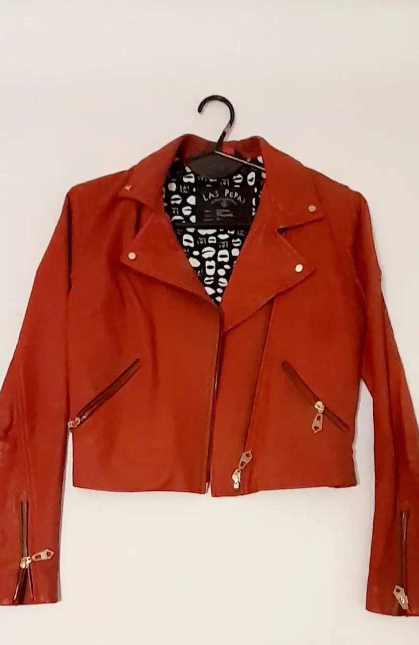 Chaqueta de cuero roja estilo biker para mujer. Ideal para un look rocker y moderno. Con detalles de cierres dorados y forro interior con estampado.