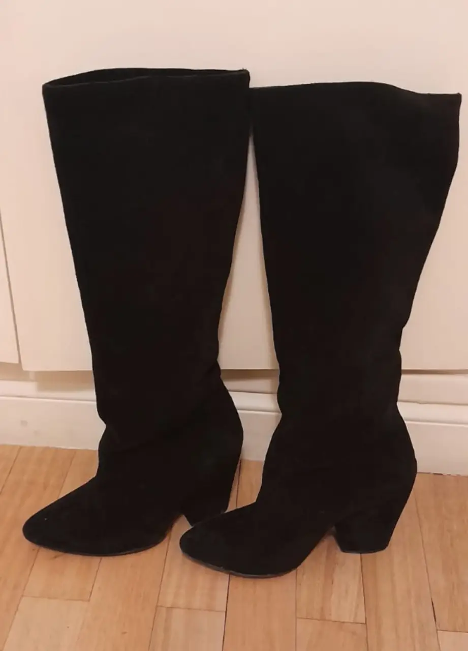 Botas altas de gamuza negra, ideales para un look elegante y moderno. Perfectas para combinar con faldas, vestidos o pantalones ajustados. Un clásico atemporal para tu guardarropa.