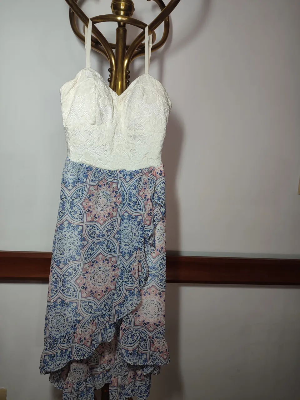 Vestido blanco con encaje en la parte superior y falda estampada con volados. Ideal para eventos de día o salidas.