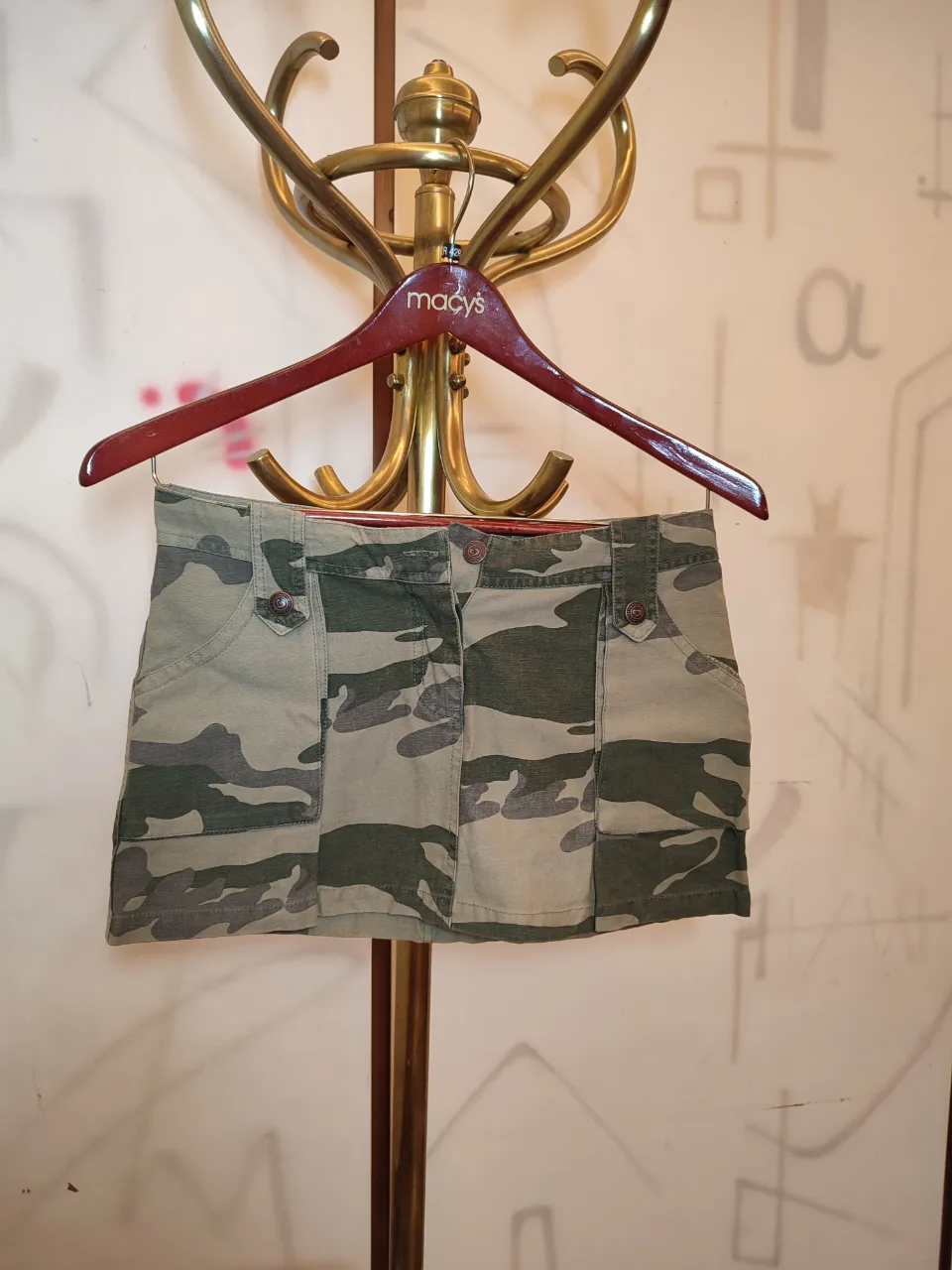 Pollera corta de jean con estampa de camuflaje. Tiene bolsillos y detalles de bordado en la parte trasera.