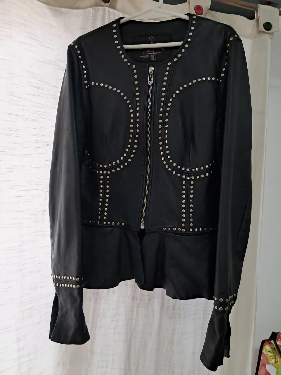 Campera de cuero negra con tachas plateadas y volado en la cintura. Diseño único y canchero, ideal para darle un toque rockero a tu outfit.