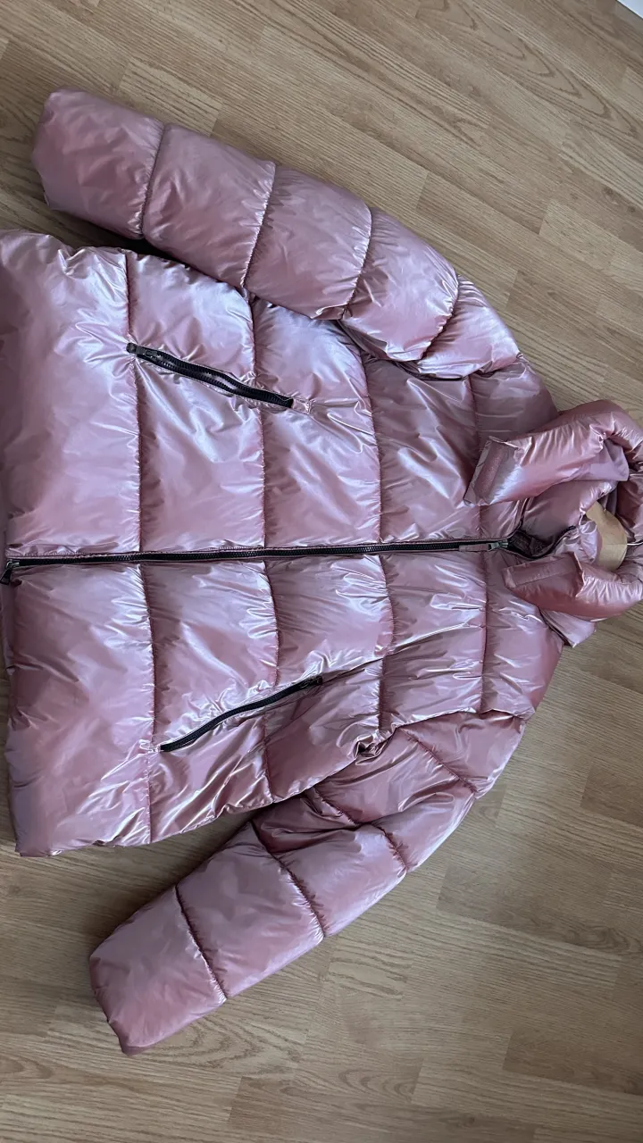 Campera acolchada rosa metalizada con cuello alto y cierre.