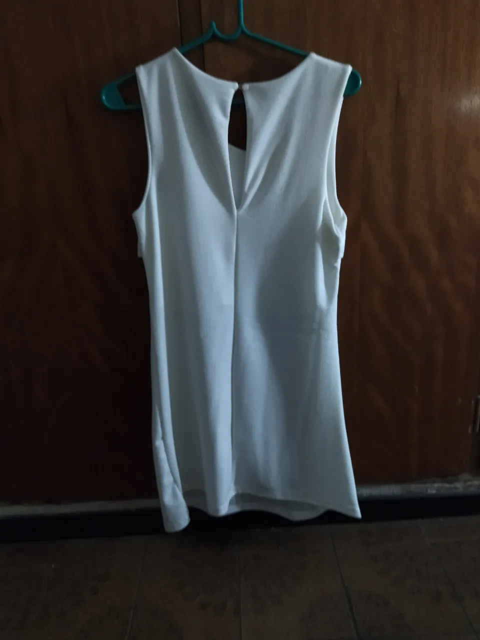 Remera blanca sin mangas con volados en el escote.