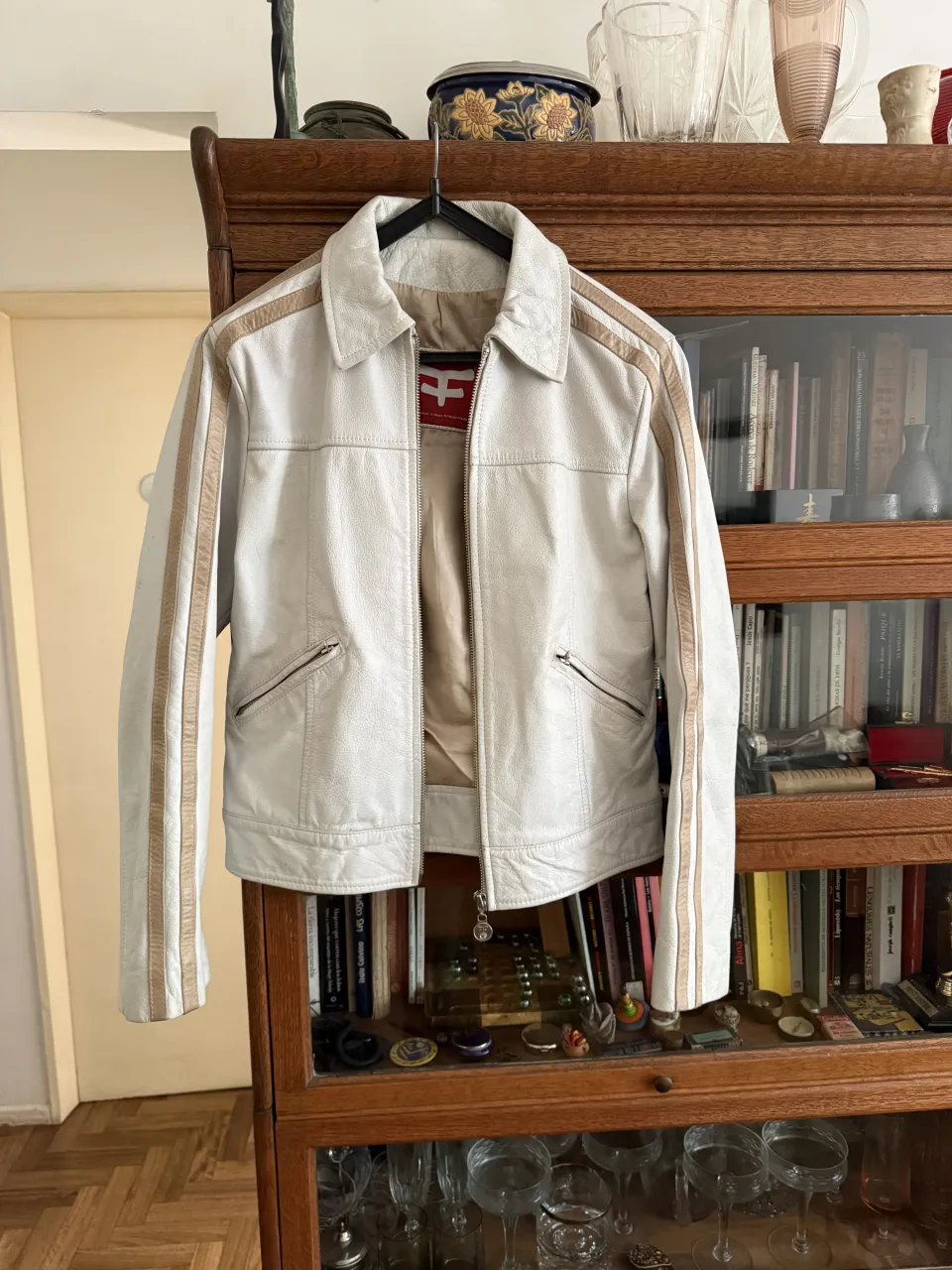 Campera blanca de cuero con detalles en los laterales de las mangas y cuello. Cierre frontal y bolsillos con cierre. Kosiuko vintage