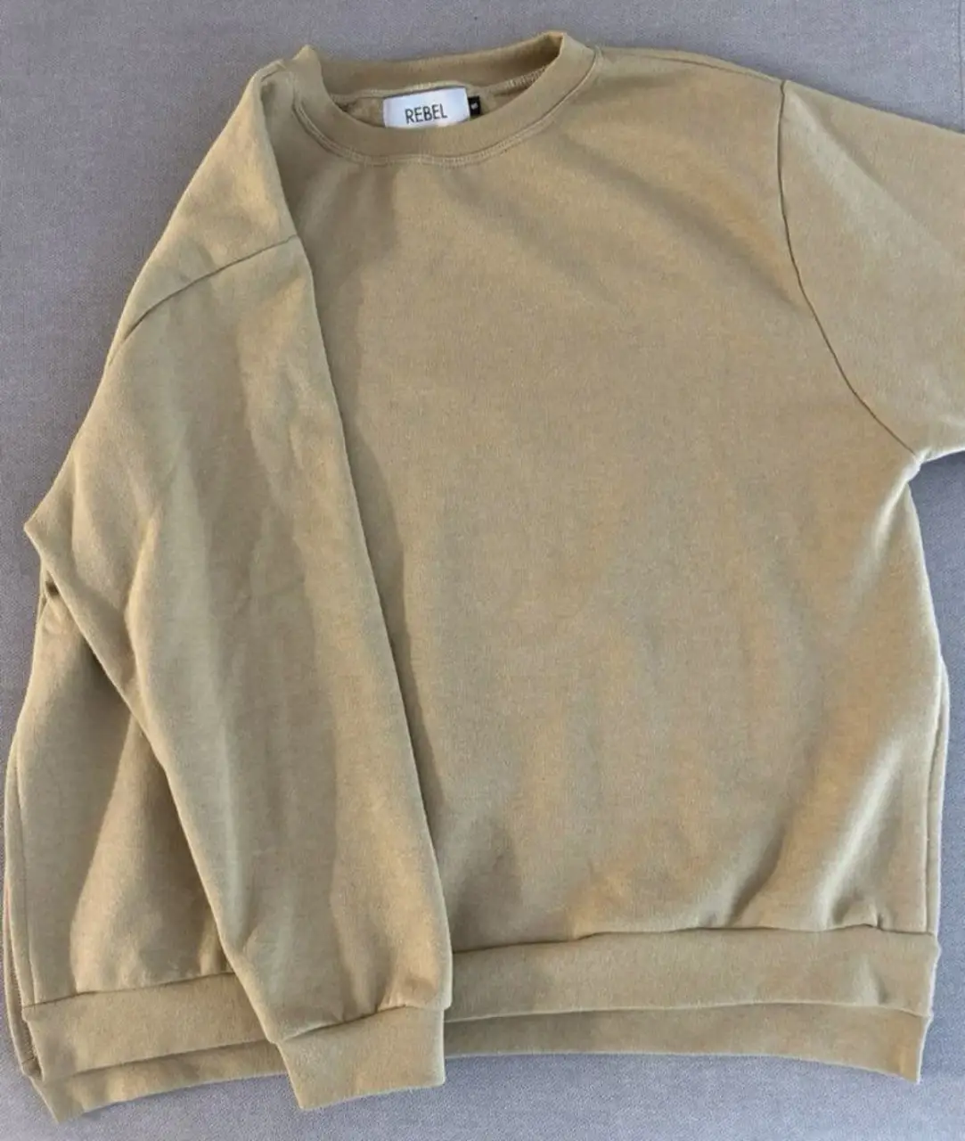 Buzo de cuello redondo color khaki, ideal para un look casual y cómodo. Confeccionado en un tejido suave y de calidad, este buzo es perfecto para el día a día. El diseño simple y versátil lo convierte en una prenda imprescindible en tu guardarropa.