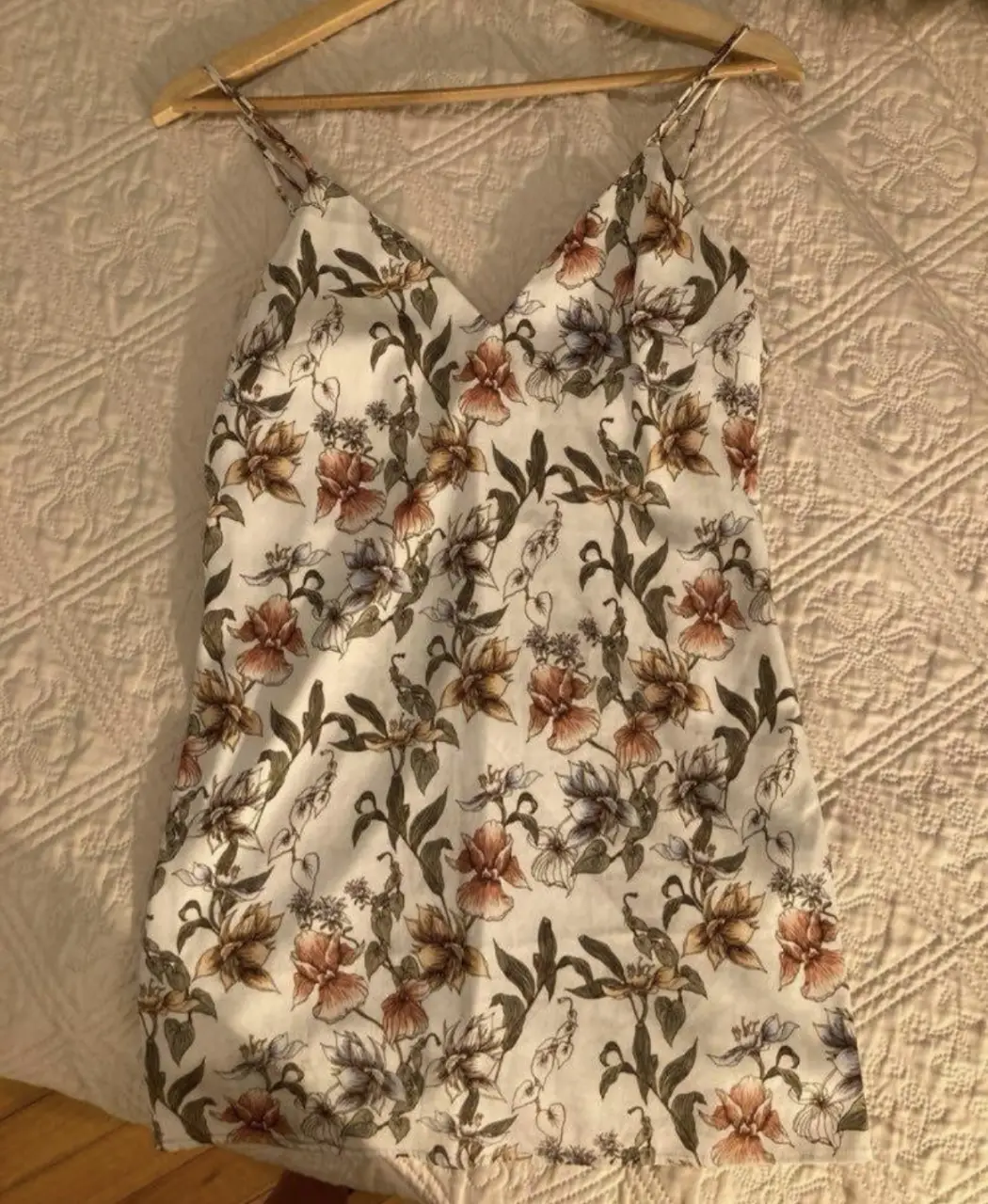 Vestido mini con estampado floral, ideal para el verano. Confeccionado en tela ligera y fresca, perfecto para un look casual y femenino. Cuenta con tirantes finos y un escote en V.