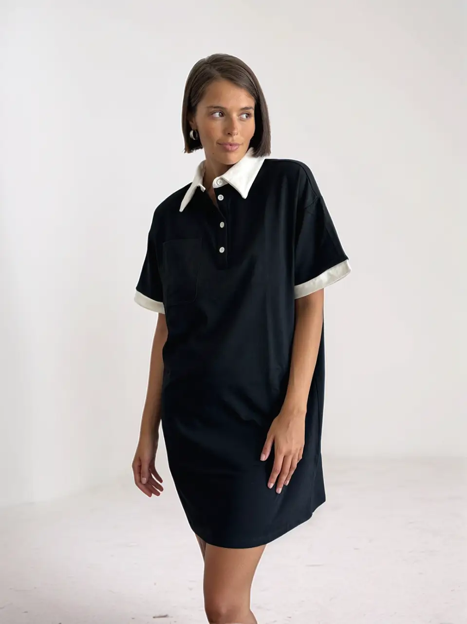 Vestido mini negro con cuello polo blanco y detalles en las mangas. Un clásico moderno para un look casual y chic.