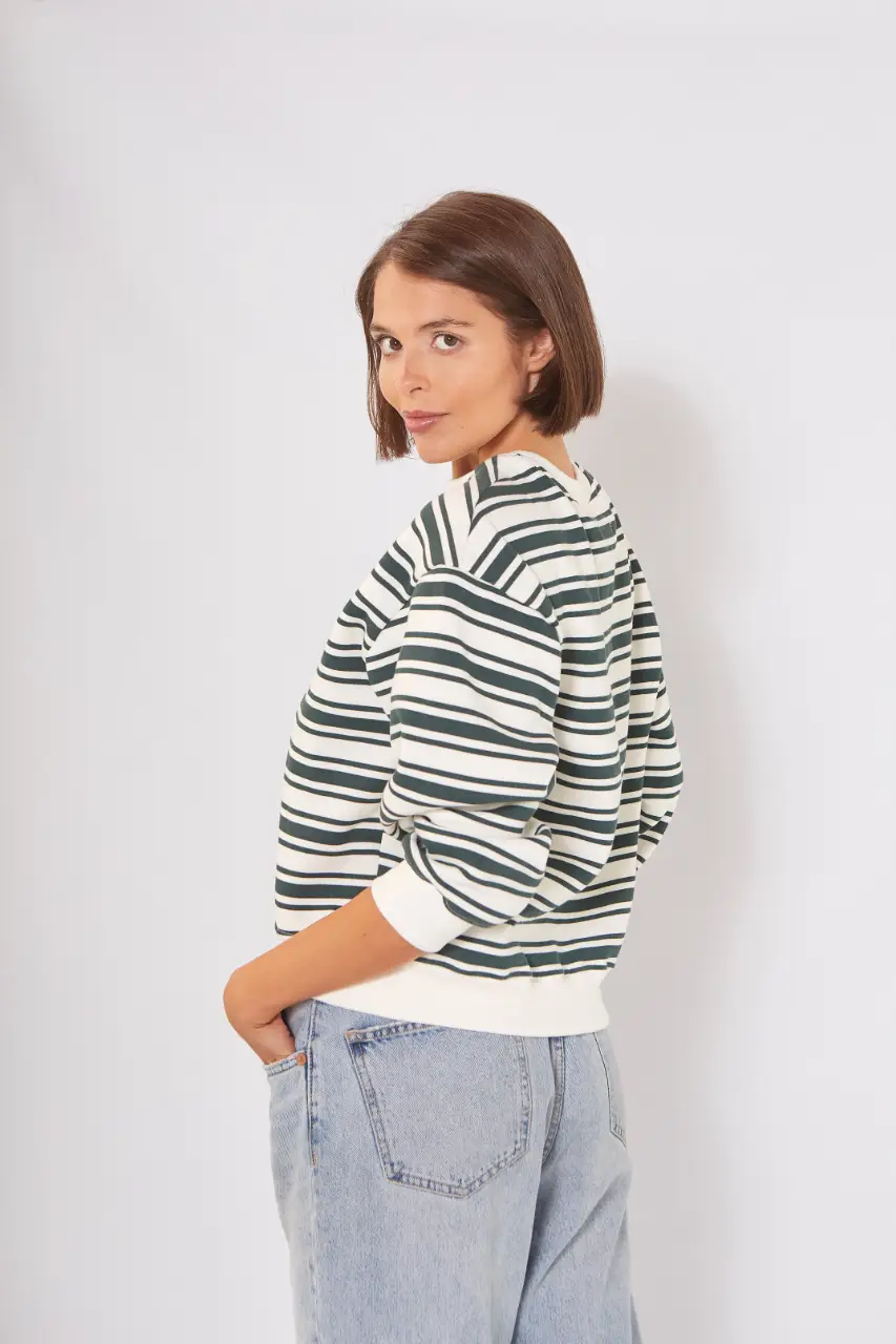 Buzo de cuello redondo a rayas horizontales en verde oscuro y blanco. Corte holgado y puños en color blanco. Ideal para un look casual y cómodo.