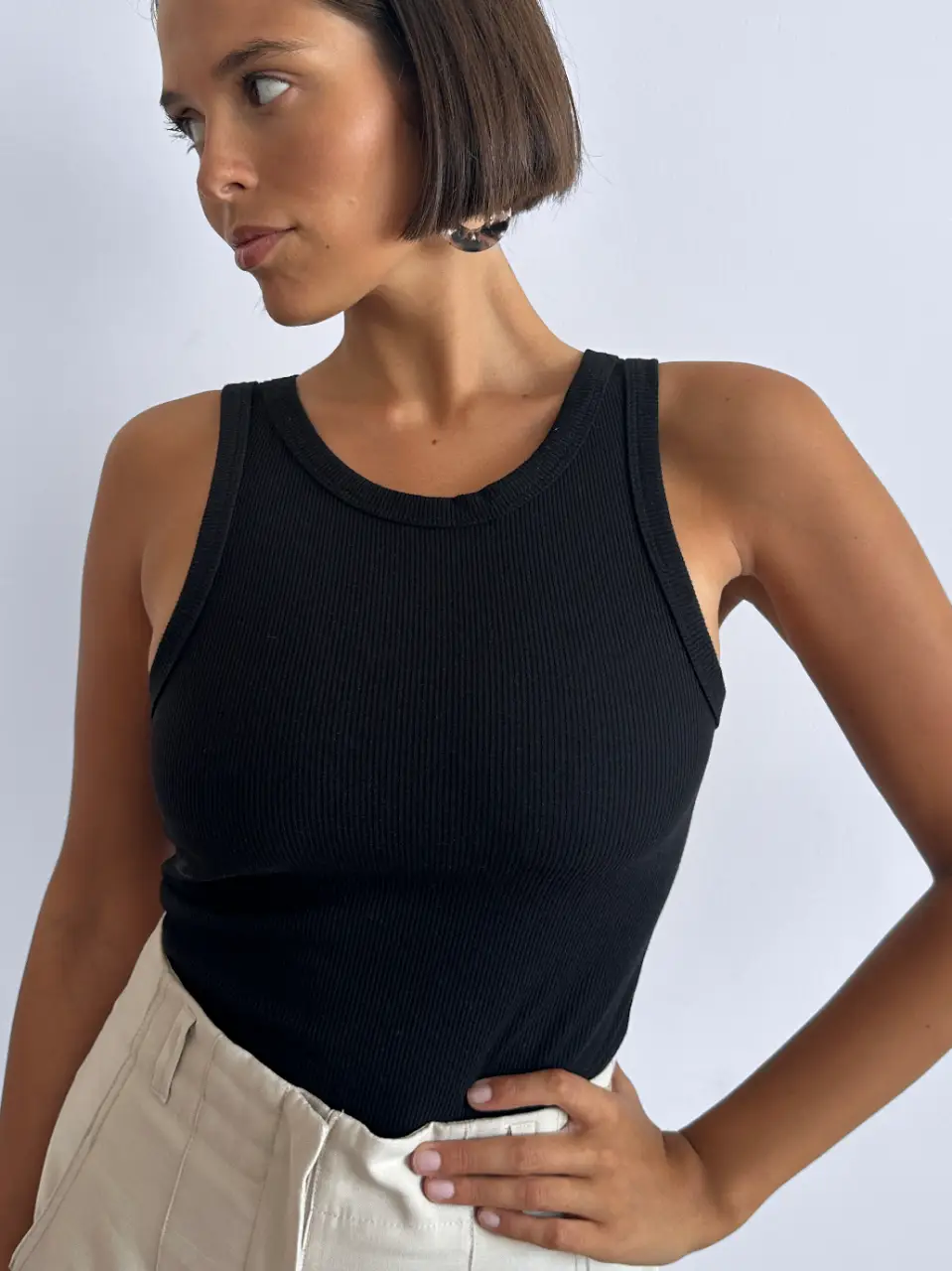 Musculosa negra de corte ajustado, ideal para un look casual y moderno. Confeccionada en tejido de punto suave y cómodo, perfecta para combinar con jeans o pantalones de vestir.