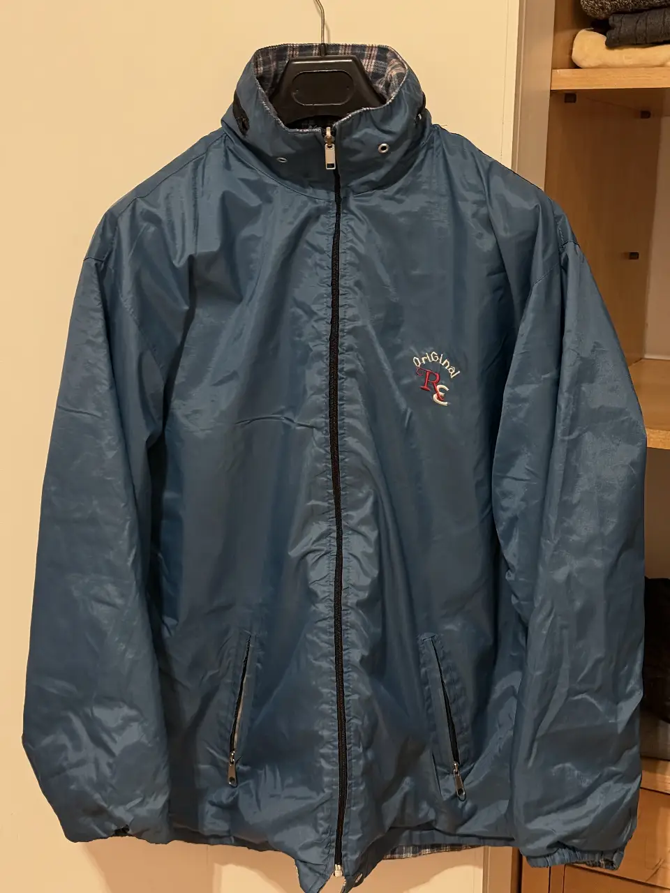 Campera rompevientos azul reversible con interior a cuadros. Ideal para usar en días de lluvia o viento. Posee cierre y bolsillos.
