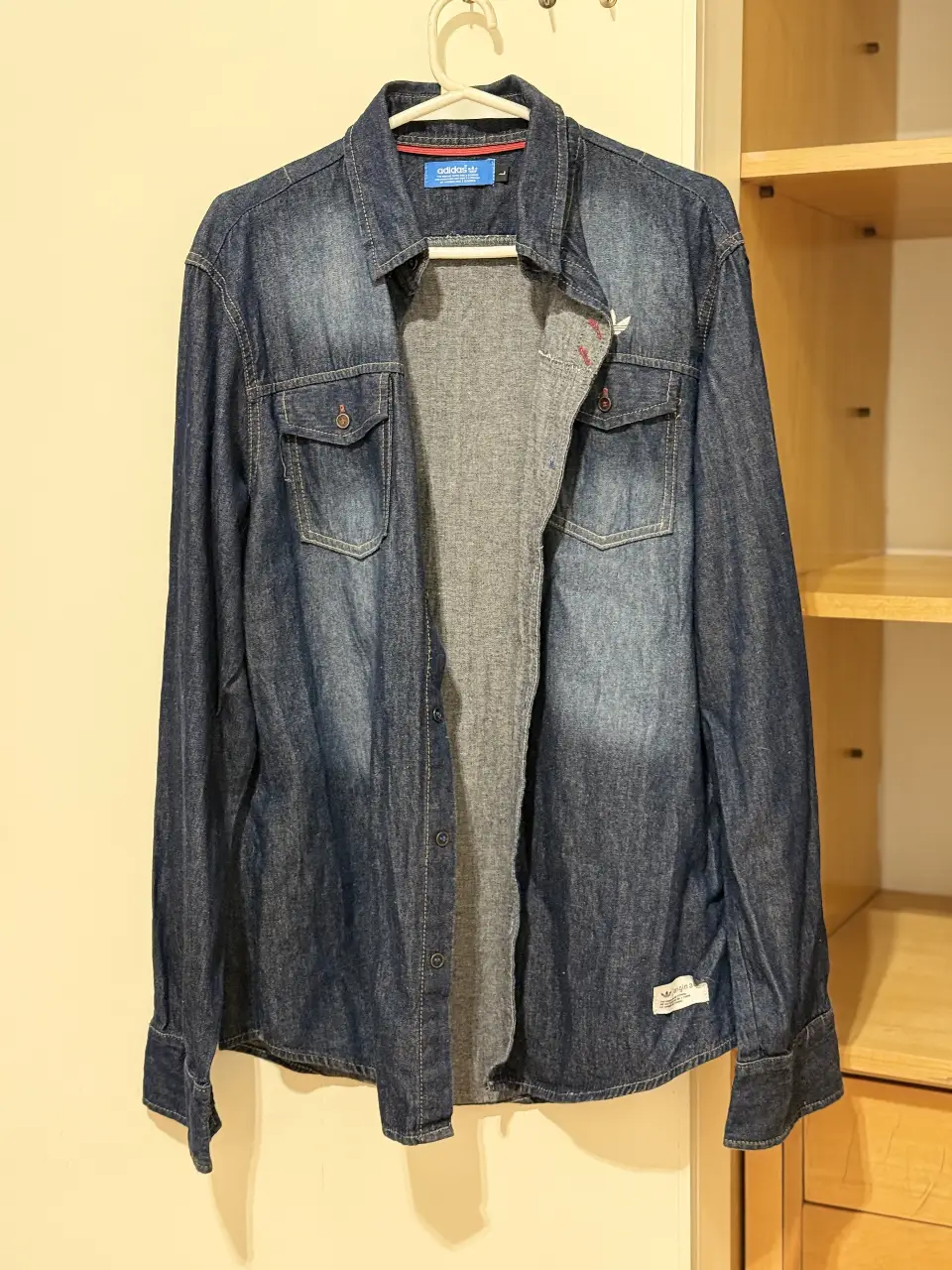 Camisa de jean Adidas para hombre, talle L. Clásica camisa  azul, con dos bolsillos delanteros y el logo de la marca bordado. Ideal para un look casual y versátil.