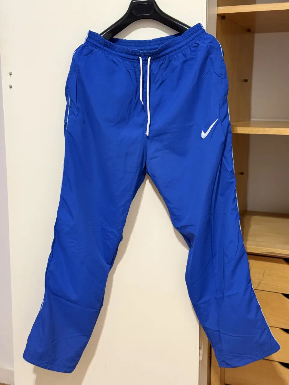 Pantalón deportivo Nike azul, con detalles blancos y logo de la marca. Ideal para actividades físicas o uso casual.