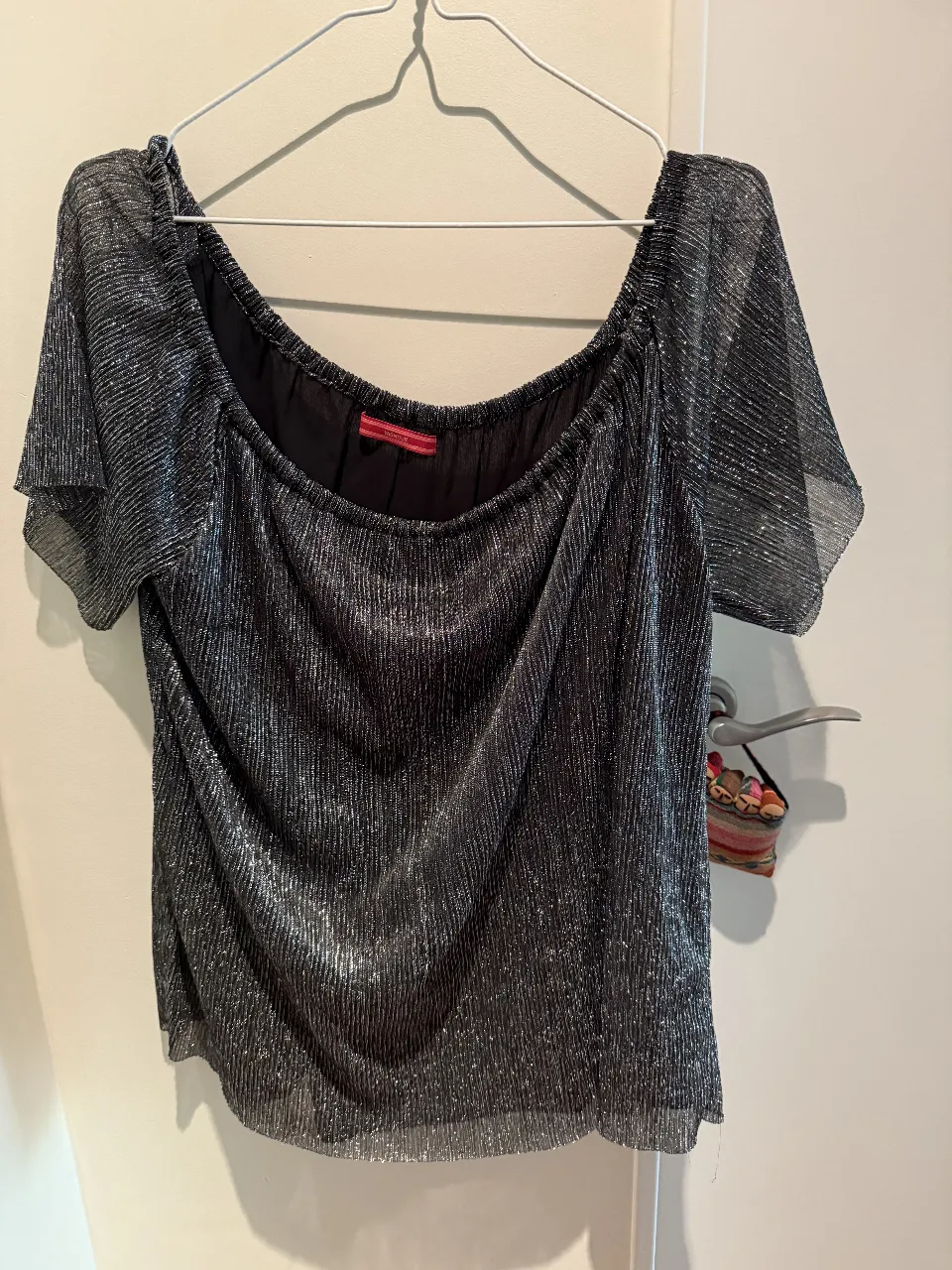 Blusa plateada con brillos, escote Bardot y mangas cortas acampanadas. Ideal para una salida o fiesta.