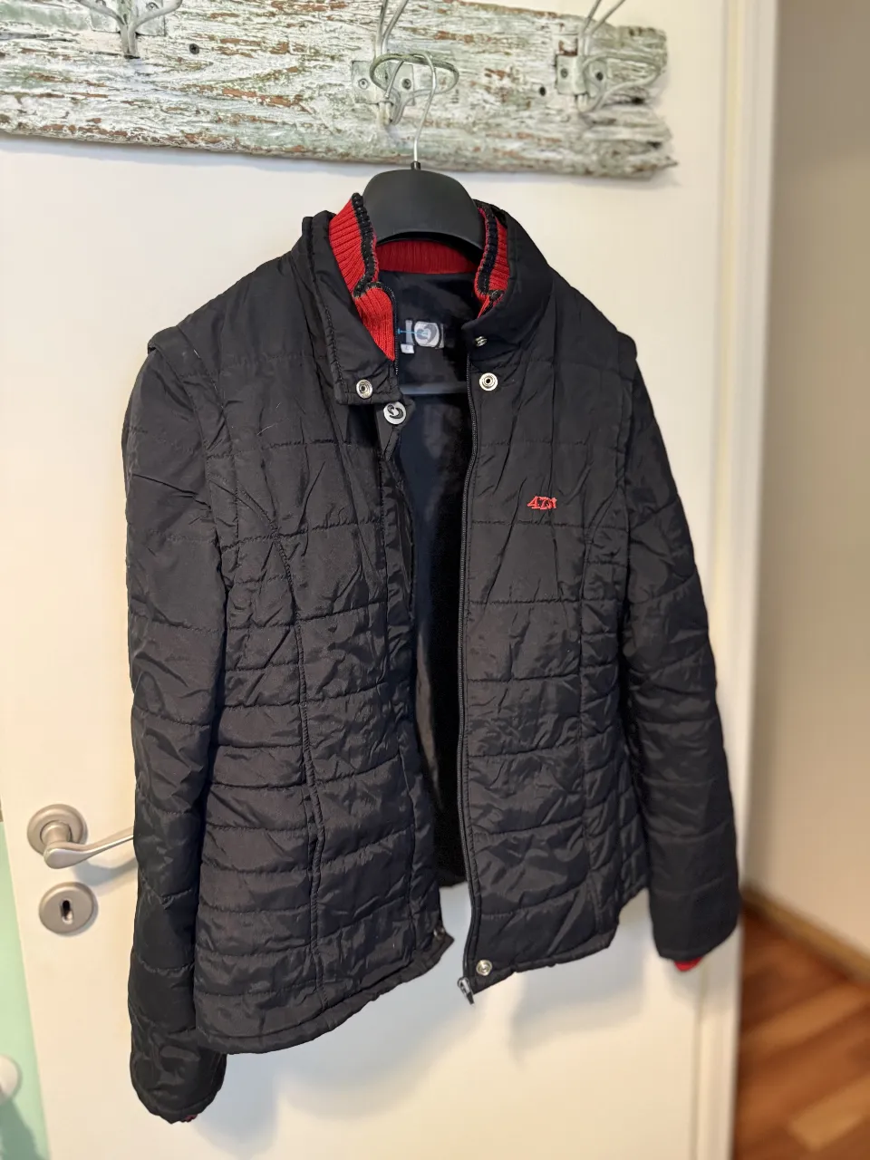 Campera acolchada negra con cuello y puños rojos. Ideal para un look casual y canchero.