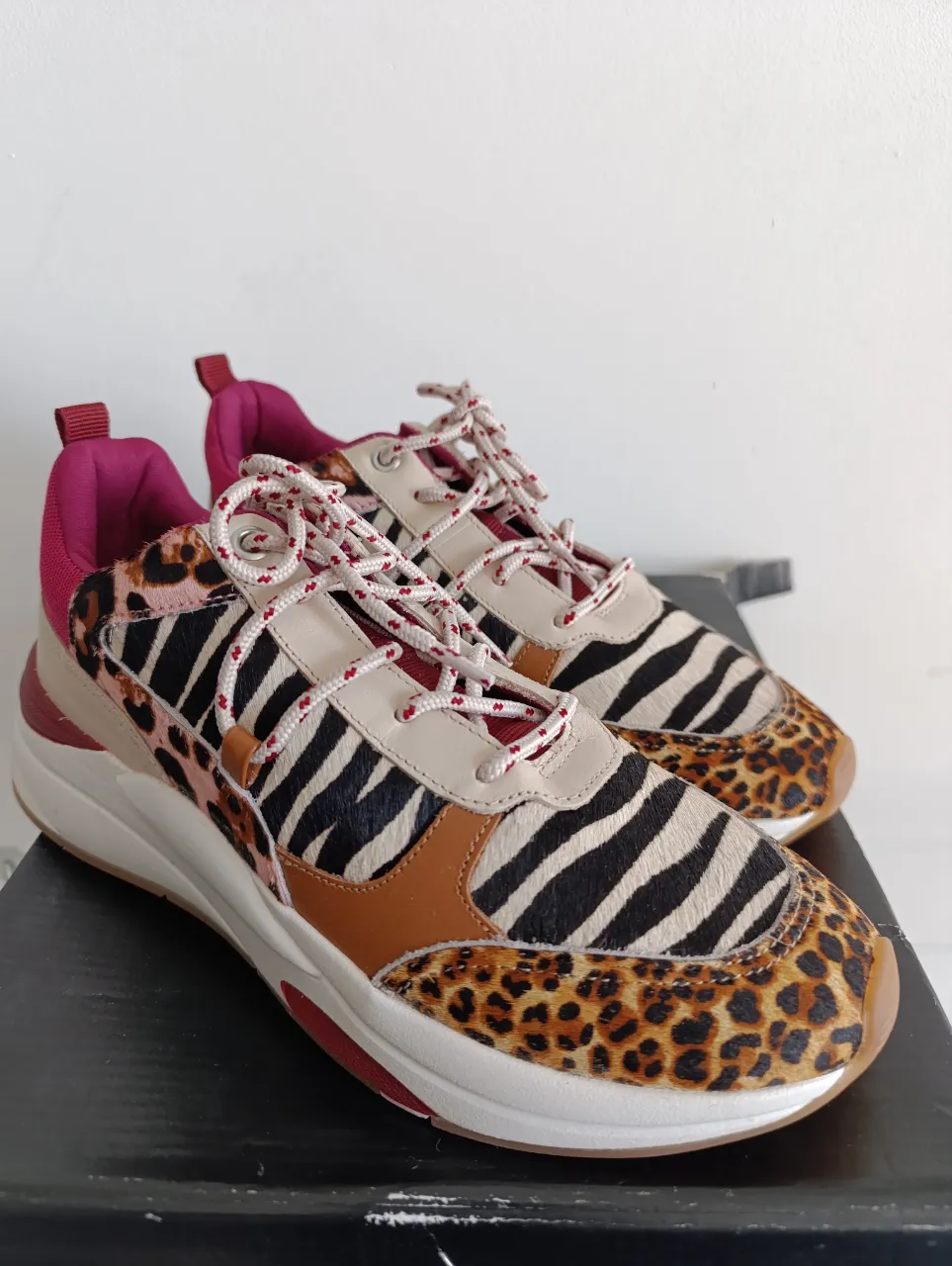 Zapatillas de mujer con estampado animal print de leopardo y cebra. Detalles en marrón y borgoña. Suela blanca y marrón. Ideales para un look moderno y audaz.