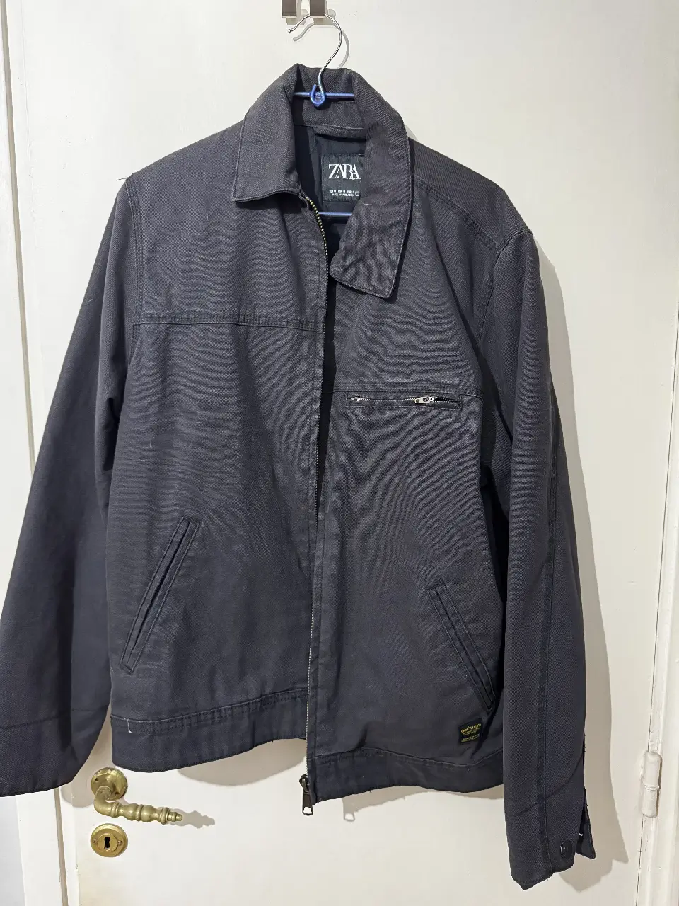 Campera tipo bomber de hombre, color negro, de la marca Zara. Con cierre frontal y bolsillos. Ideal para un look casual y moderno.