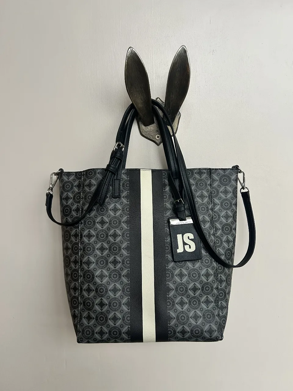 Bolso tote de mujer Jackie Smith Monogram negro gris y blanco. Diseño con franja central blanca y detalles en negro. Incluye correa ajustable y tag con iniciales JS.