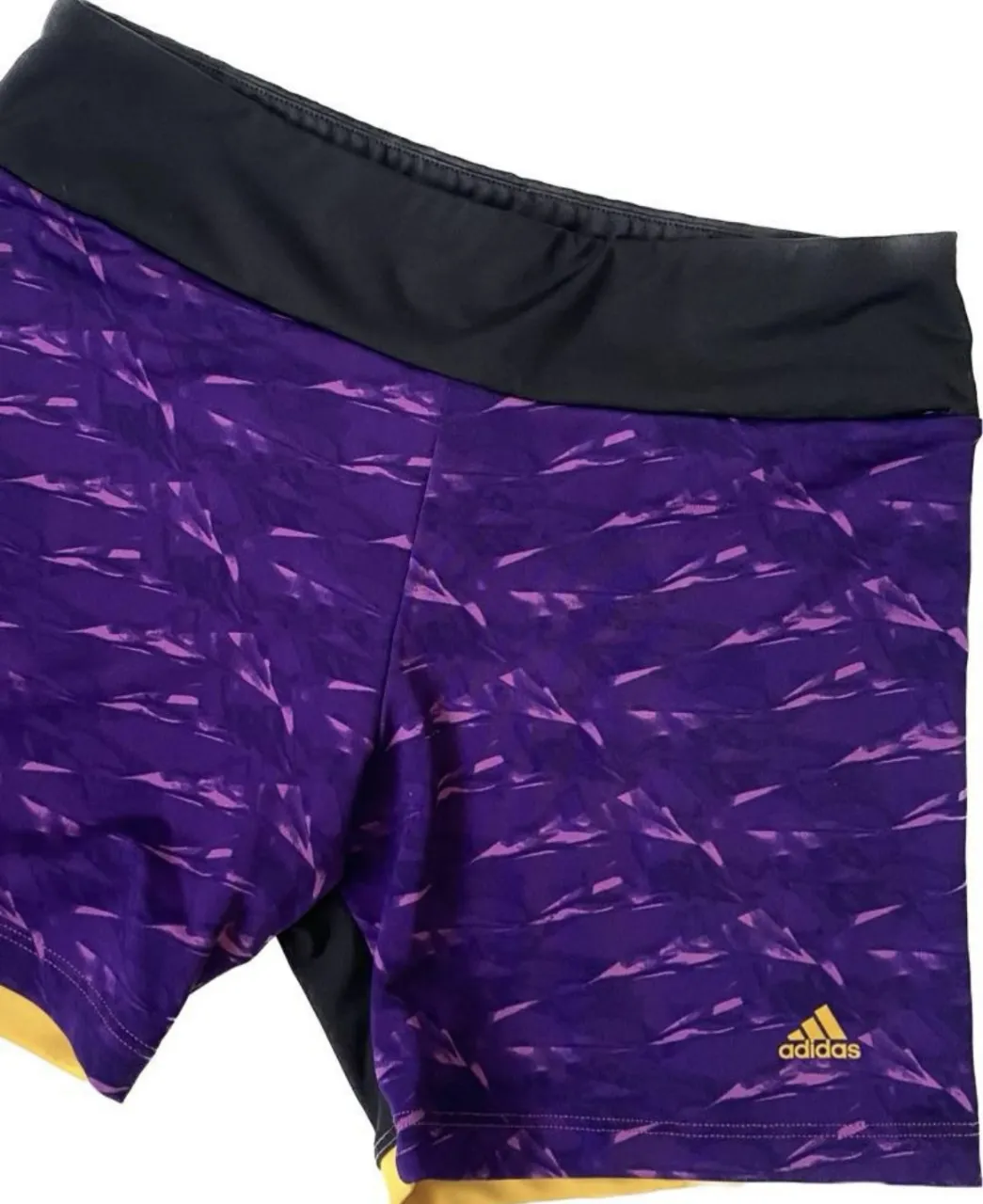 Short calza deportivo Adidas original para mujer, con diseño en tonos violetas y detalles en naranja. Ideal para actividades físicas.