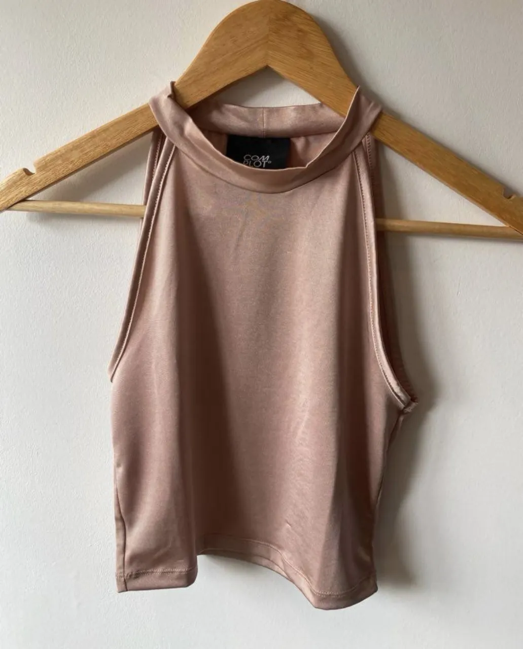 Top halter de satén color rosa, ideal para una salida o evento especial. Diseño elegante y moderno.