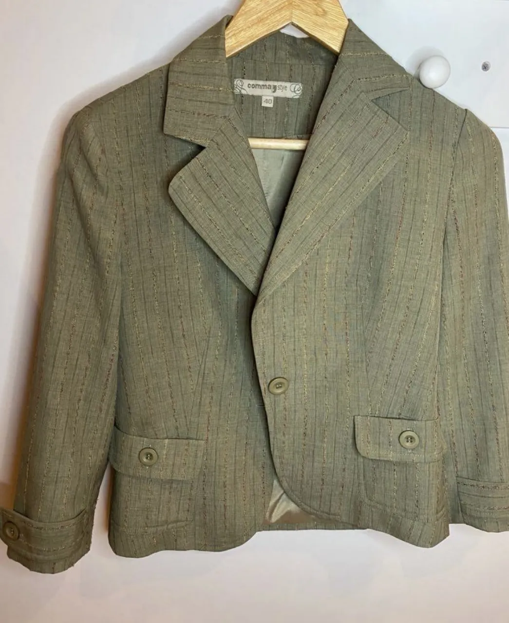 Blazer de mujer color verde con diseño a rayas. Posee dos bolsillos delanteros con botones y un botón para cerrar. Marca Comma Style, talle 40.