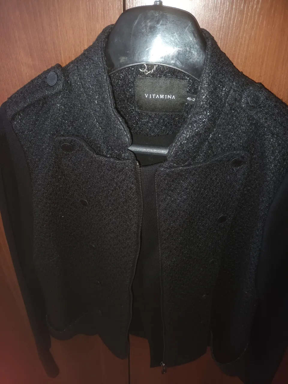 Campera negra de mujer, estilo biker, con detalles de botones en los hombros y cierre frontal. Marca Vitamina.
