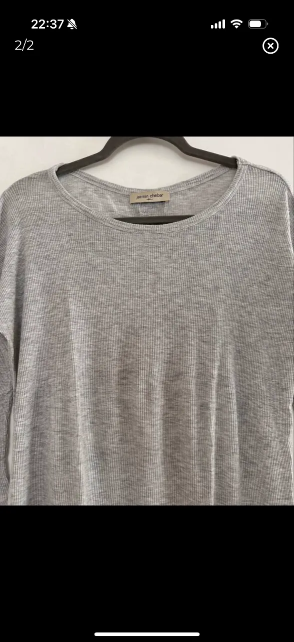 Remera larga de mujer, de tejido de punto acanalado en color gris. Cuello redondo y mangas 3/4. Ideal para un look casual y cómodo.
