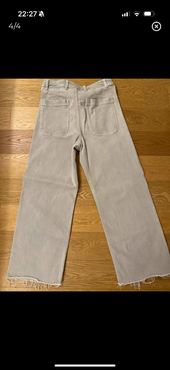 Pantalón suelto de mujer, color gris claro, con corte ancho y flecos en el borde. Marca Bimba y Lola. Talle 42.