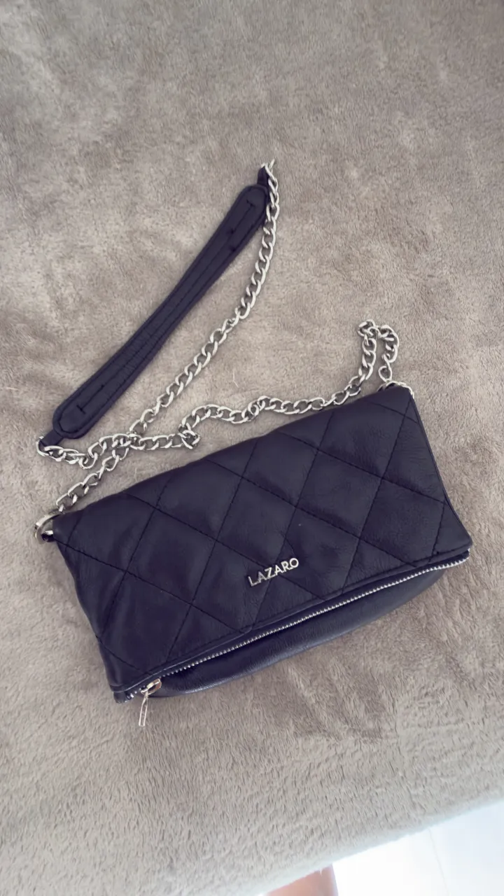 Cartera negra acolchada con cadena plateada. Ideal para salir o para un look más elegante.