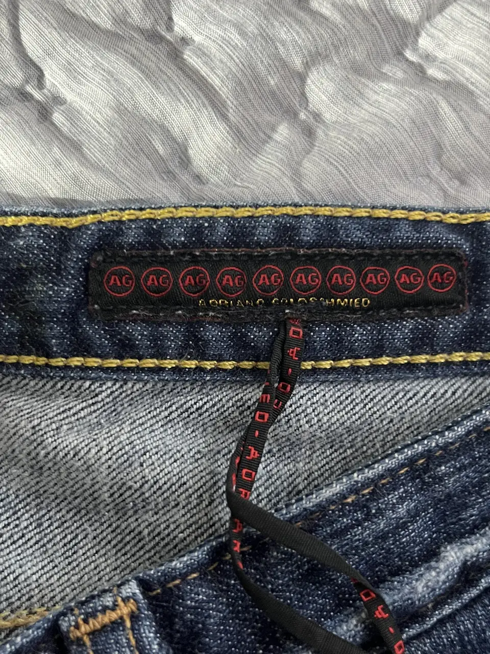 Jeans rectos de la marca AG Adriano Goldschmied, con etiqueta y detalles de costura en amarillo. Un clásico de jean para cualquier ocasión.