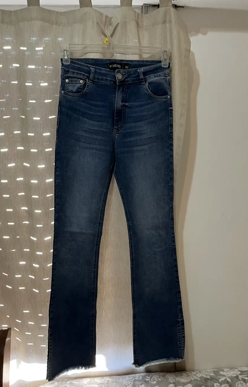 Jeans de mujer tiro alto, con corte campana y detalles de roturas en el bajo. Talle 26.