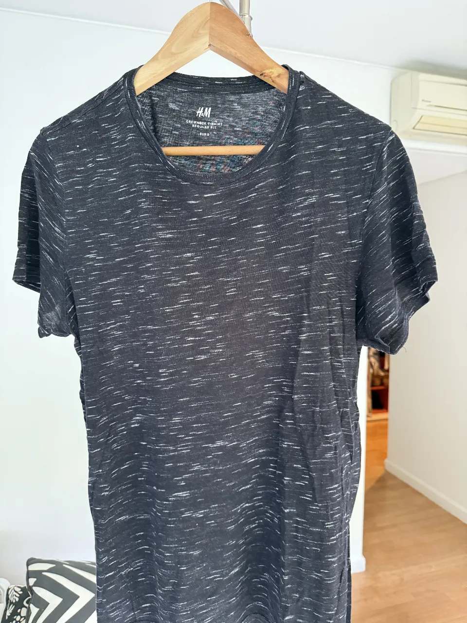Remera de hombre H&M, de manga corta, color negro con detalles blancos. Talle S, corte regular fit, ideal para un look casual y cómodo.