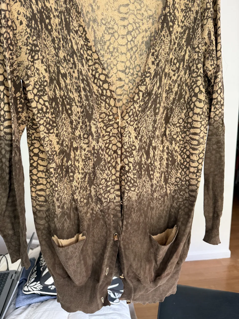 Cardigan de mujer con estampado de serpiente en tonos marrones y beige. Tiene dos bolsillos delanteros y botones para cerrar. Ideal para un look casual y canchero.