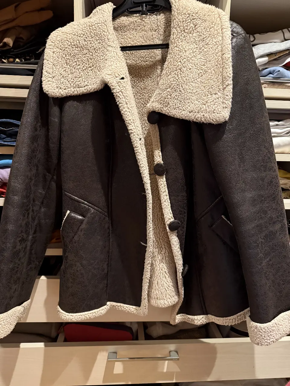  sacon tipo campera de cuero sintético marrón oscuro con cuello y forro de piel sintética color crema. Posee dos bolsillos delanteros y cierre con botones. Ideal para el invierno.