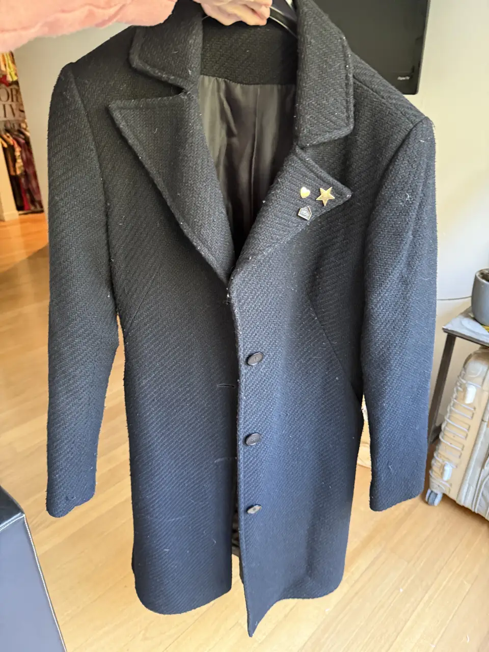 tapado negro de paño, con solapas clásicas y detalles de botones. Ideal para un look elegante y abrigado en invierno. Cuenta con detalles decorativos en la solapa.