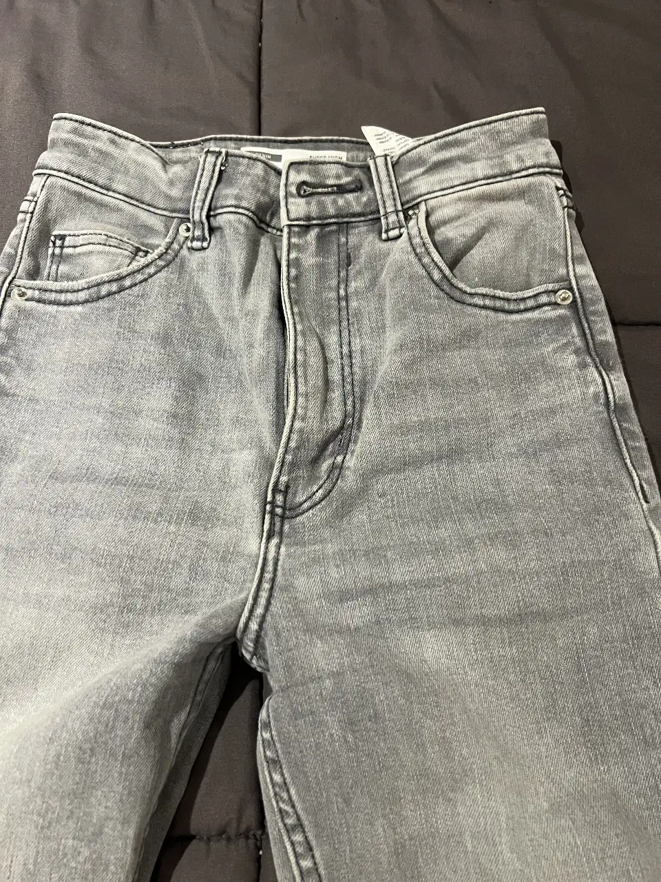 Jeans rectos de hombre en color gris. Tiro medio, ideal para un look casual y moderno. Perfecto para combinar con cualquier outfit.