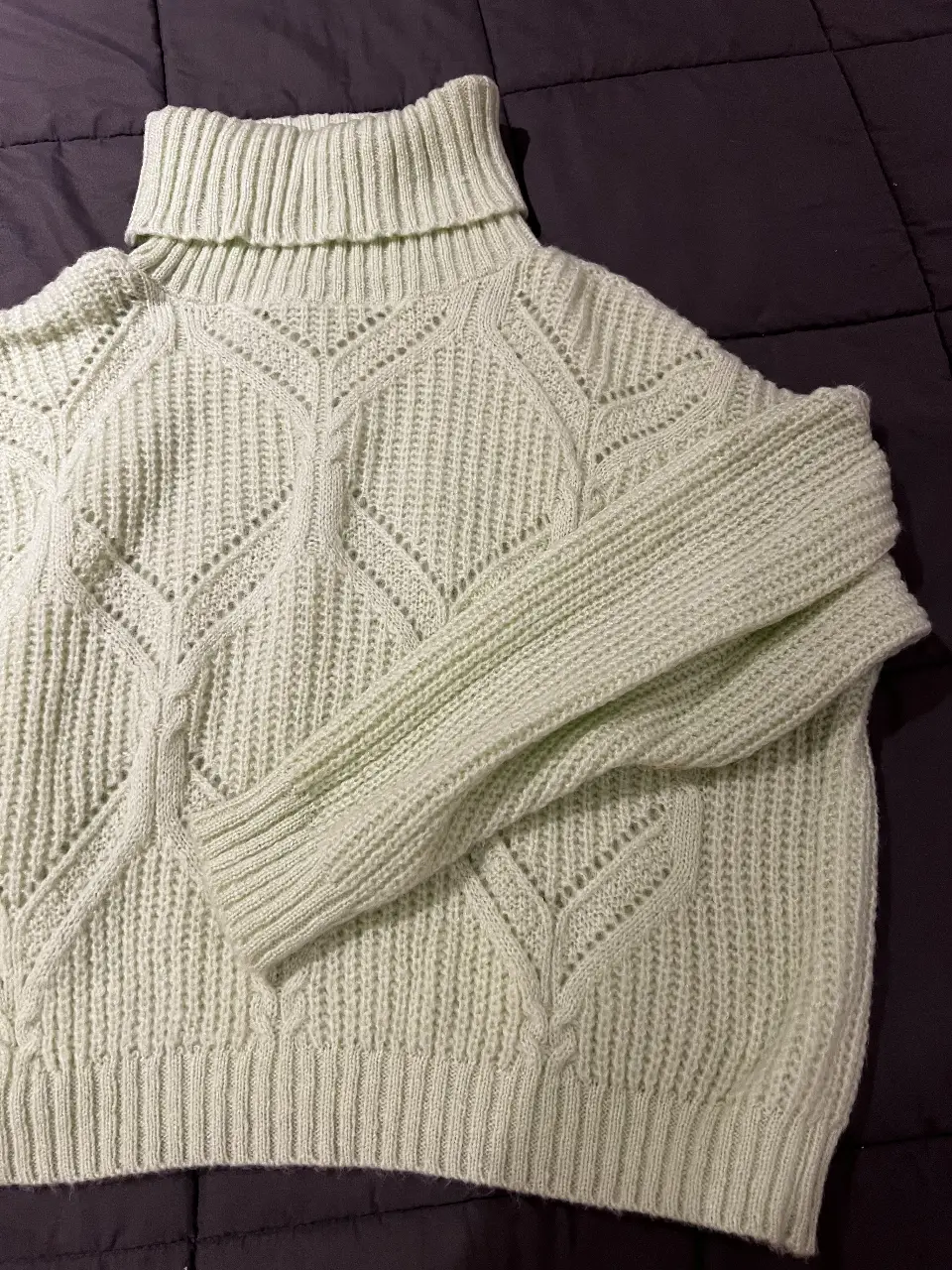 Sweater de cuello alto tejido en punto calado, ideal para un look casual y abrigado. Perfecto para combinar con jeans o pantalones de vestir.