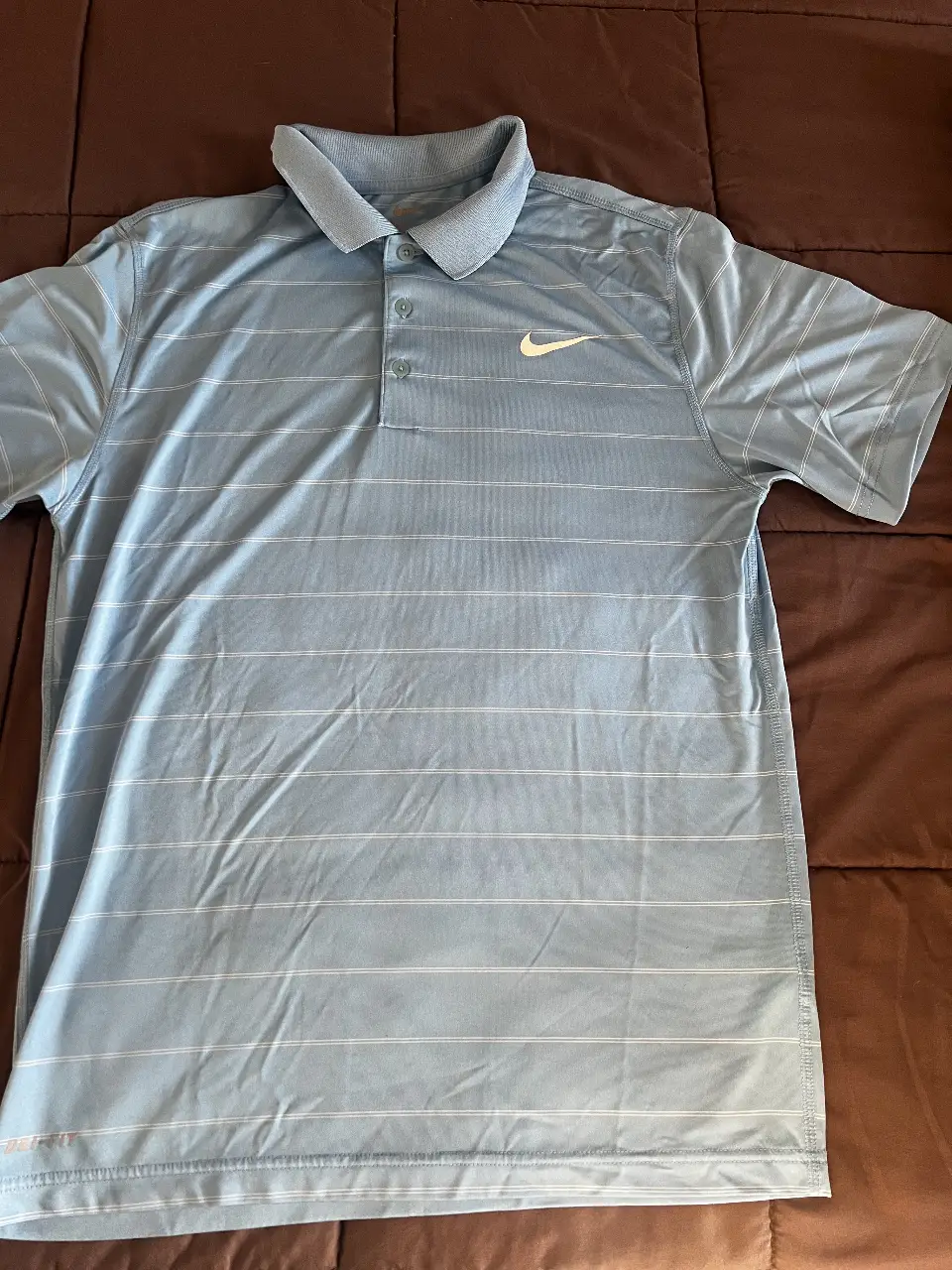 Remera deportiva Nike de hombre, celeste con rayas blancas horizontales y logo de la marca. Ideal para actividades deportivas.